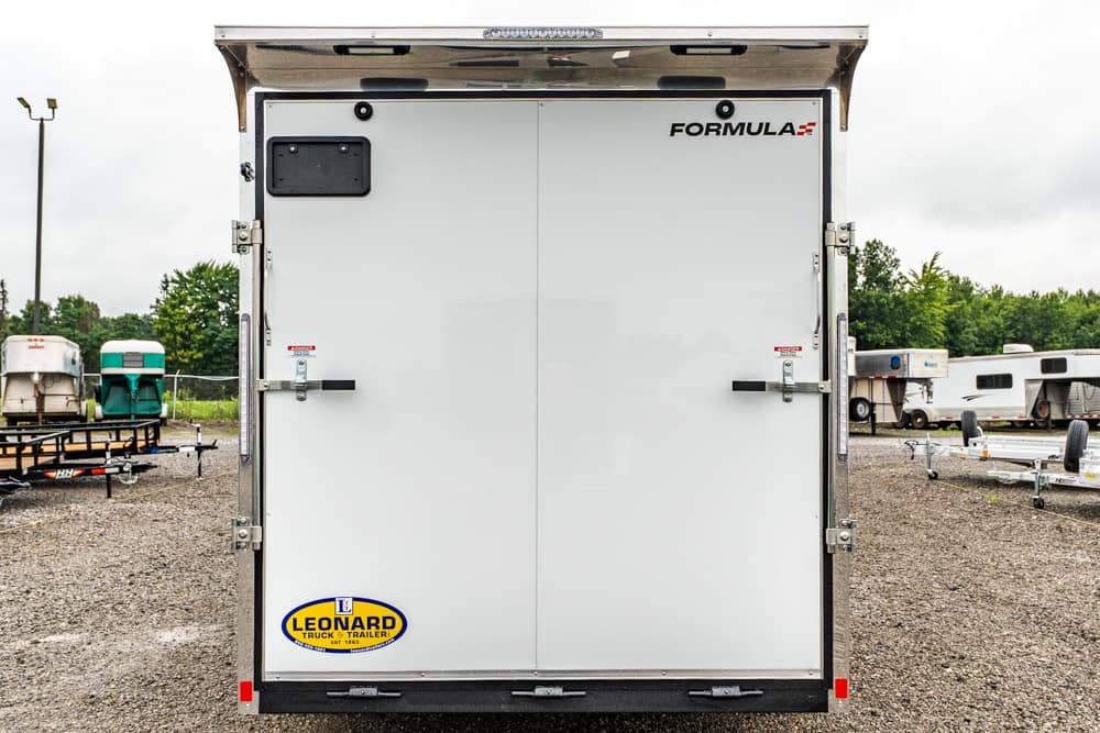 Back of a white double-door trailer with 'FORMULA' branding and a Leonard trailer sticker at the bottom left (outdoor lot).