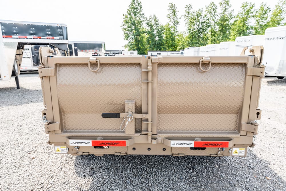 Tan diamond-plate cargo trailer in a gravel yard, rear doors with heavy latches and Horizon decals visible.