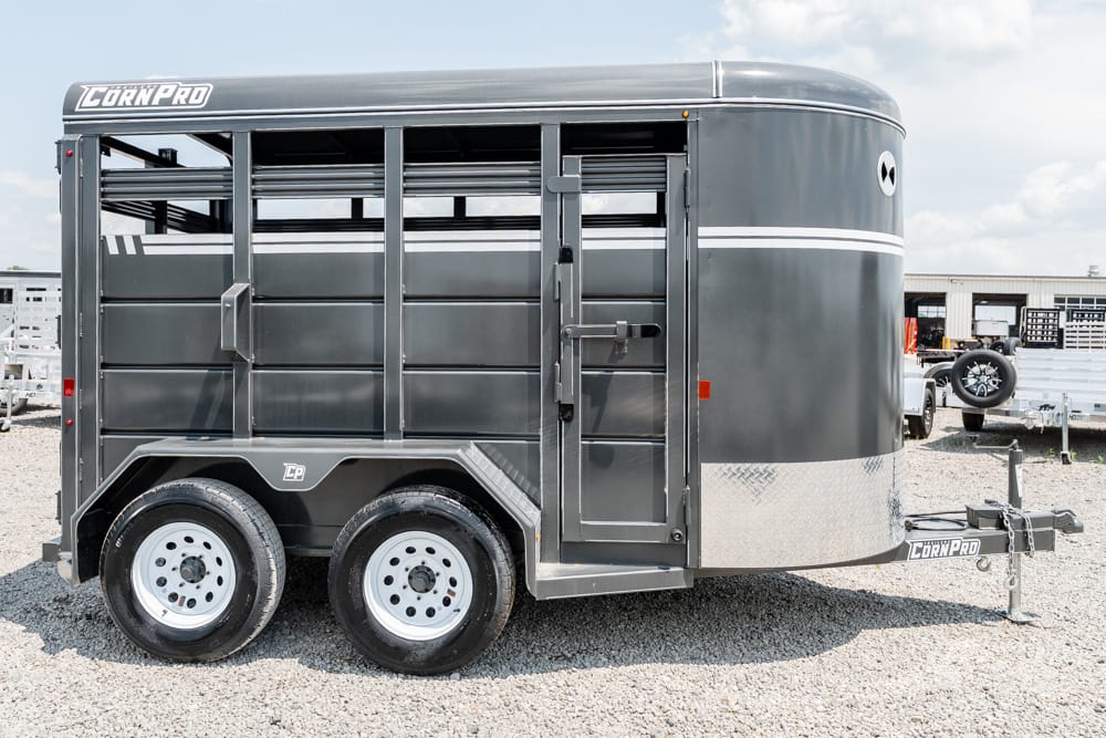 Gray Corn Pro horse trailer with two axles and side entry on a gravel lot
