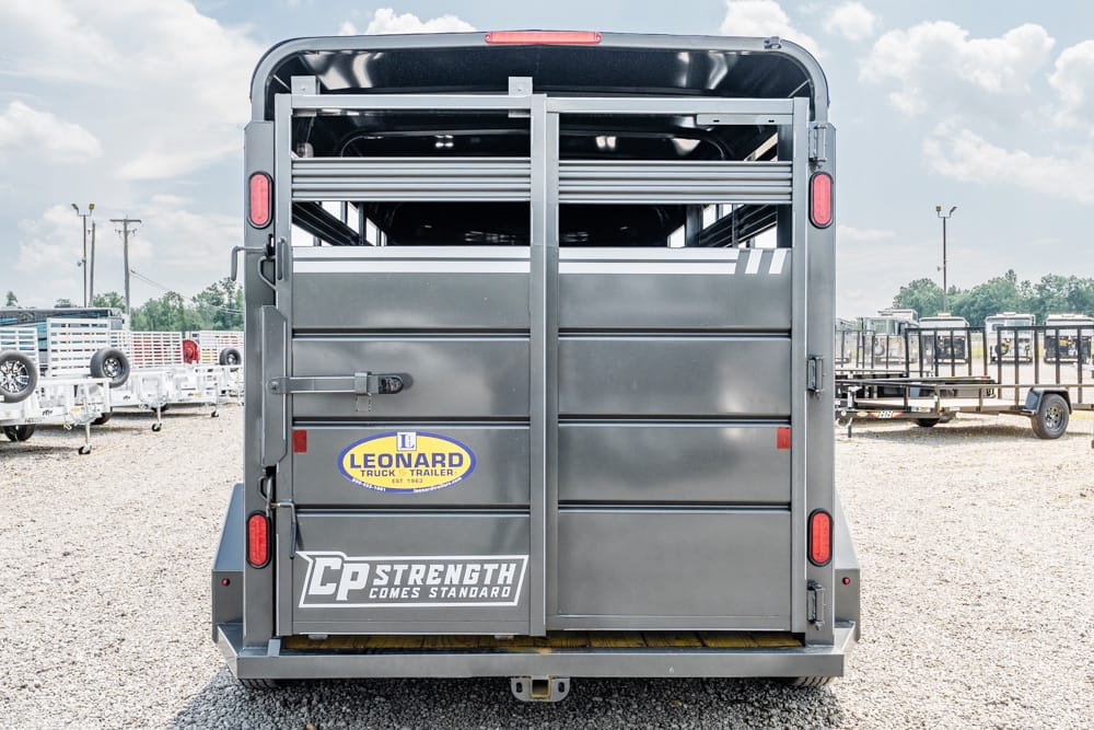 Rear view of a gray livestock trailer with vertical doors, red taillights, and metal bars; shows Leonard Truck & Trailer and CP Strength Comes Standard logos.