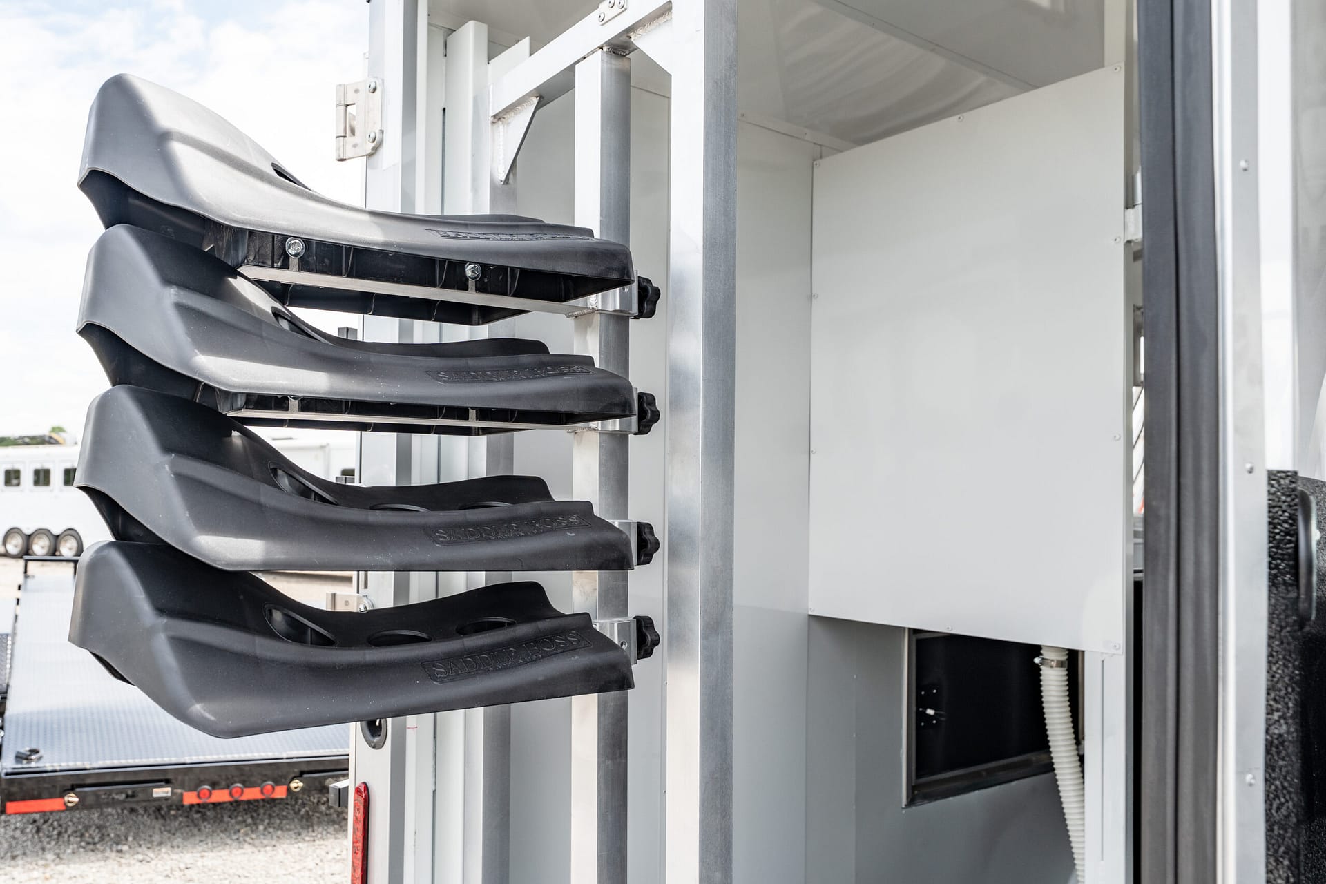 Fold-out black stair steps attached to a silver metal frame on a truck trailer surface.