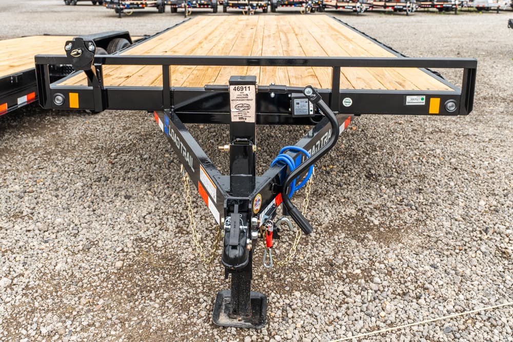 Front view of a black steel flatbed trailer hitch with wooden deck, safety chains, and a blue electrical cable coiled around the tongue