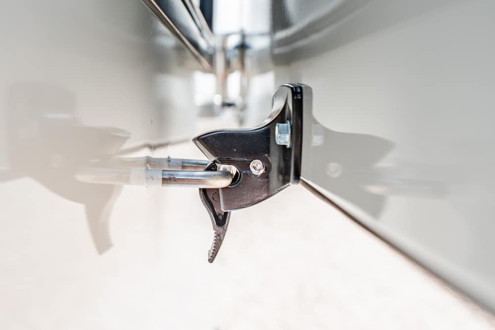 Close-up of a metal trailer door latch with a lever and securing hook