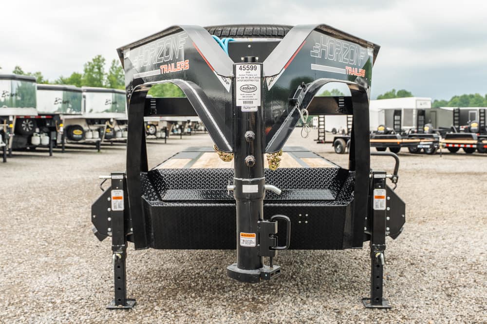 Front view of a Horizon Trailers gooseneck trailer on a gravel lot, showing the diamond-plate bed and hitch assembly with safety features