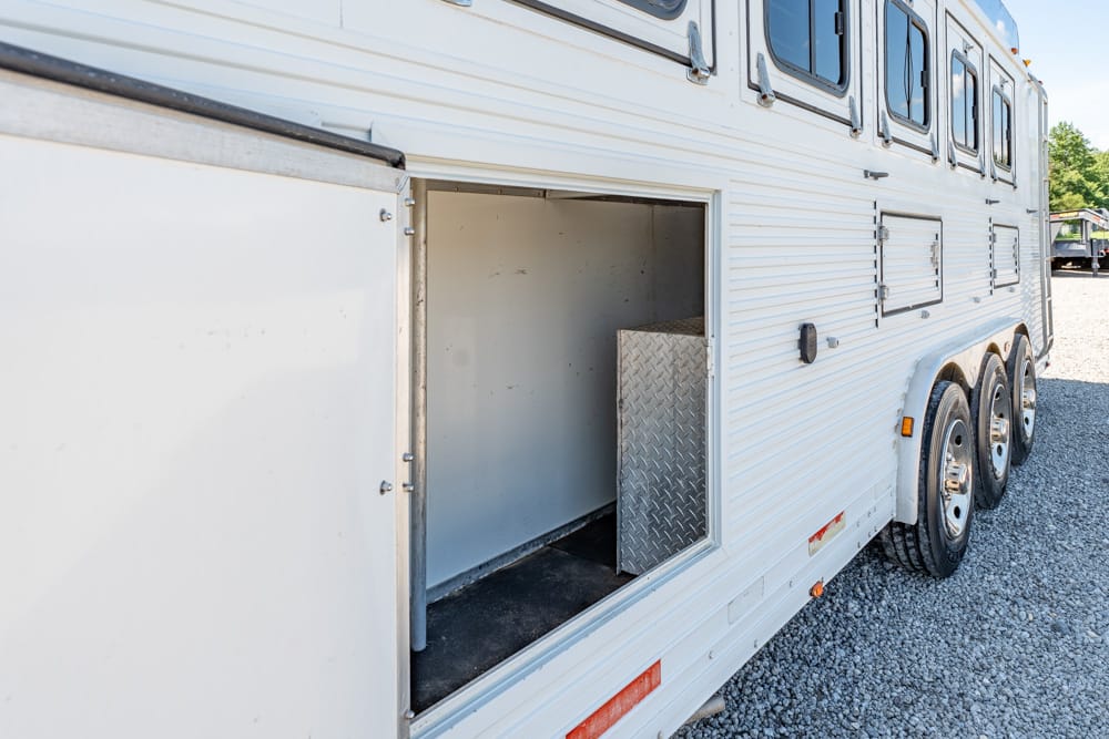 White horse trailer with an open side storage compartment showing a diamond-plate interior panel.开?