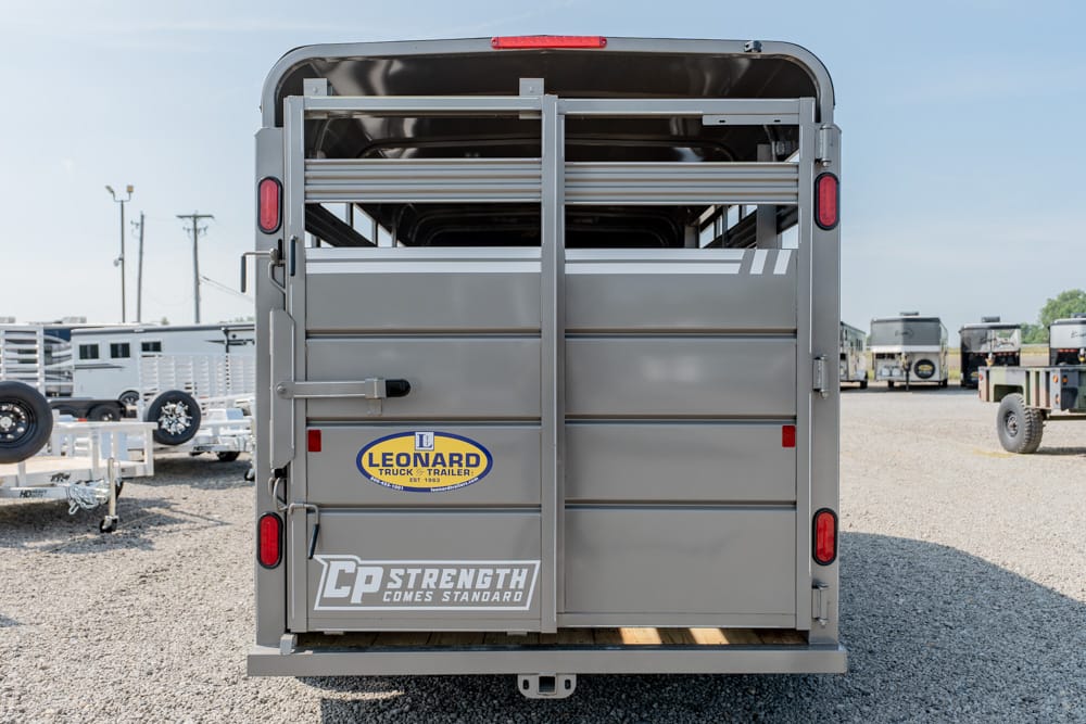 Rear view of a gray livestock trailer with dual back doors and branding stickers (Leonard Truck & Trailer, CP Strength Comes Standard)