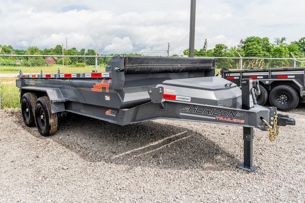 Horizon dual-axle utility trailer on gravel with a covered bed and safety chains at the hitch.