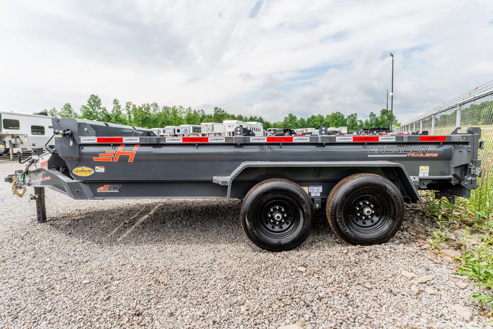Tandem-axle Horizon dump trailer on a gravel lot in an outdoor storage area, front hitch visible
