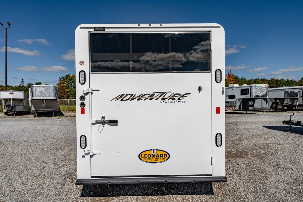 Rear view of a white Adventurer travel trailer with a large rear window and the Leonard logo at the bottom center.