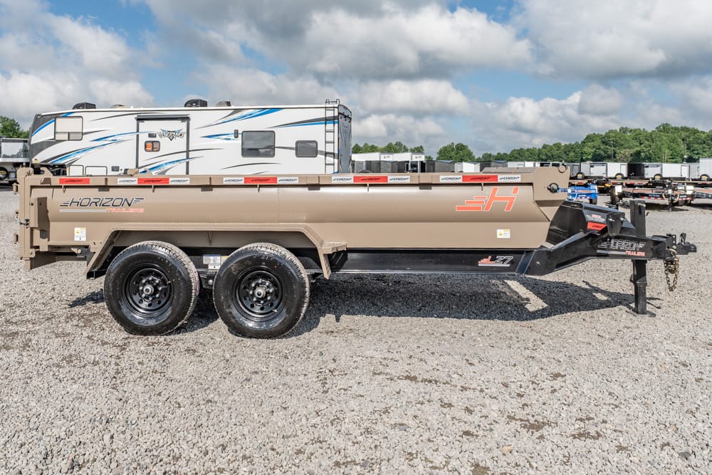Tan Horizon Trailers dump trailer with dual axles on a gravel lot, parked beside an RV in the background.