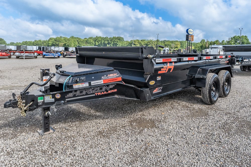 Black tandem-axle Horizon Trailers utility trailer on a gravel lot, with decals and tie-downs visible.