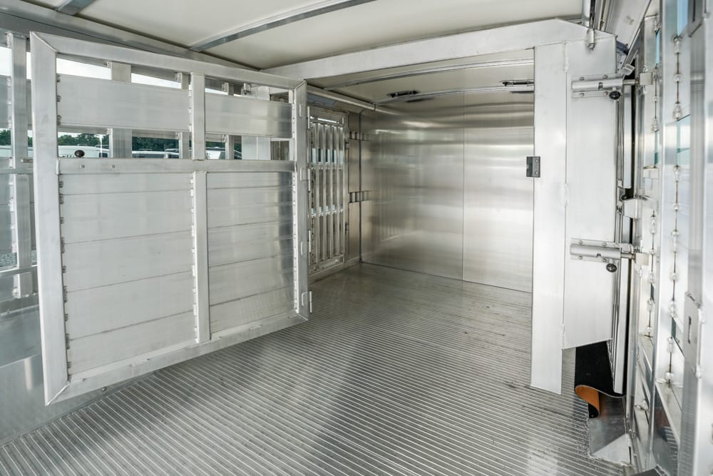Interior of a metal animal trailer with divider stalls and aluminum walls