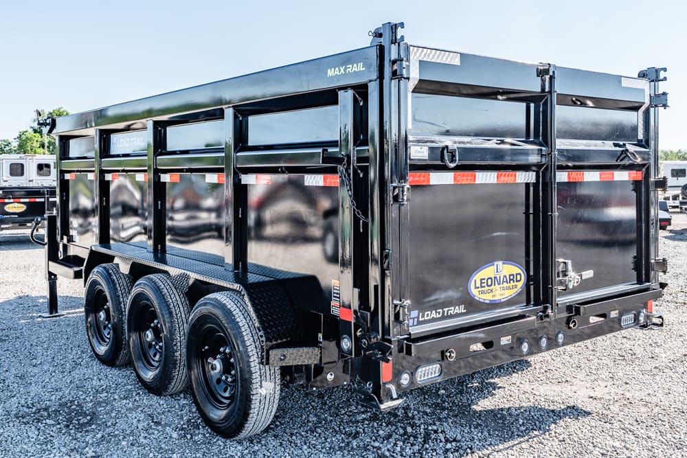 Black three-axle dump trailer with glossy black finish, red-and-white safety stripes, parked on gravel (Leonard Trailer branding).
