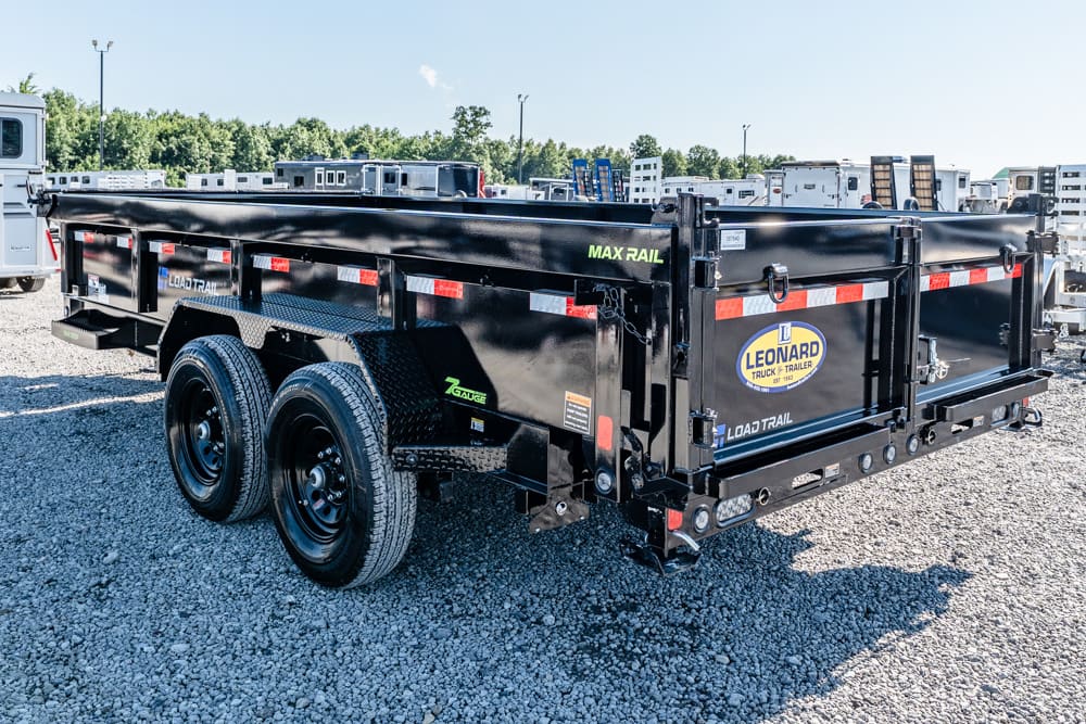 Black two-axle dump trailer on a gravel lot, showing Leonard Load Trail branding and red-and-white reflective strips on the sides.