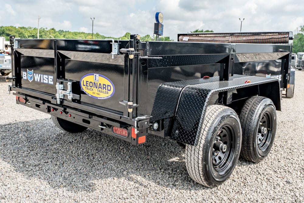 Black dual-axle dump trailer on a gravel lot, with diamond-plate fenders and Leonard Truck Trailer branding on the side.