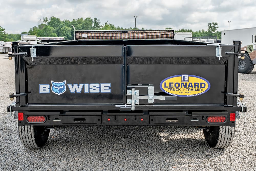 Rear view of a black dumping trailer with BowWise logo on the left and Leonard Truck & Trailer emblem on the right