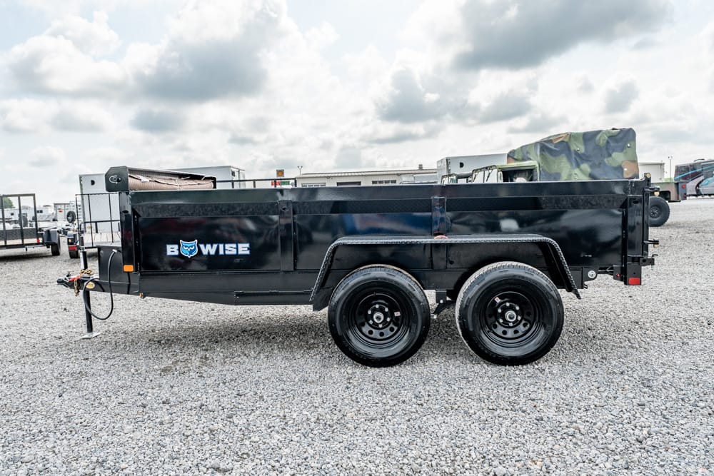 Black BowWise utility trailer with two axles and dual wheels on a gravel lot