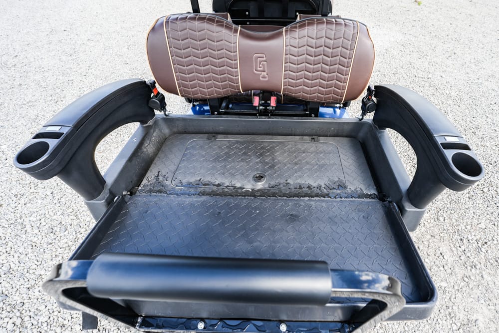 Rear view of a mobility scooter with brown cushioned seat, large foot platform, and cup-holding armrests
