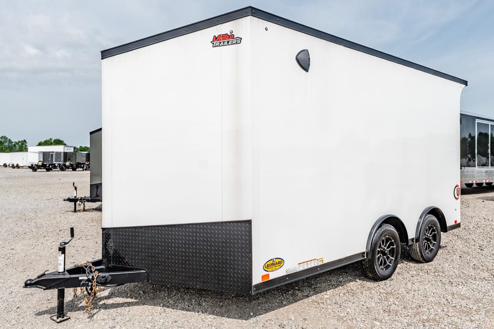 White enclosed cargo trailer with diamond-plate front, on a gravel lot.