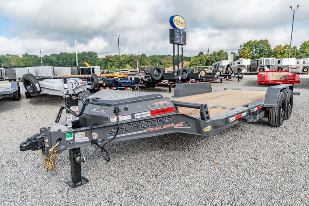 Flatbed trailer by Horizon Trailers in a gravel lot with other trailers in background.