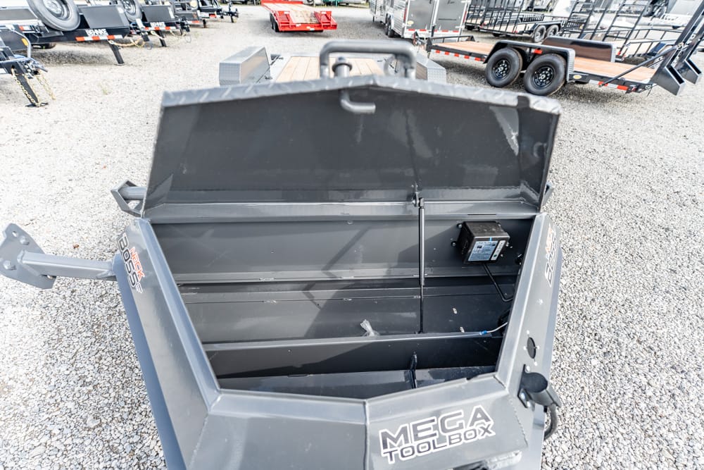 Open MEGA TOOLBOX storage chest mounted on a trailer, showing its empty metal interior with the lid raised.