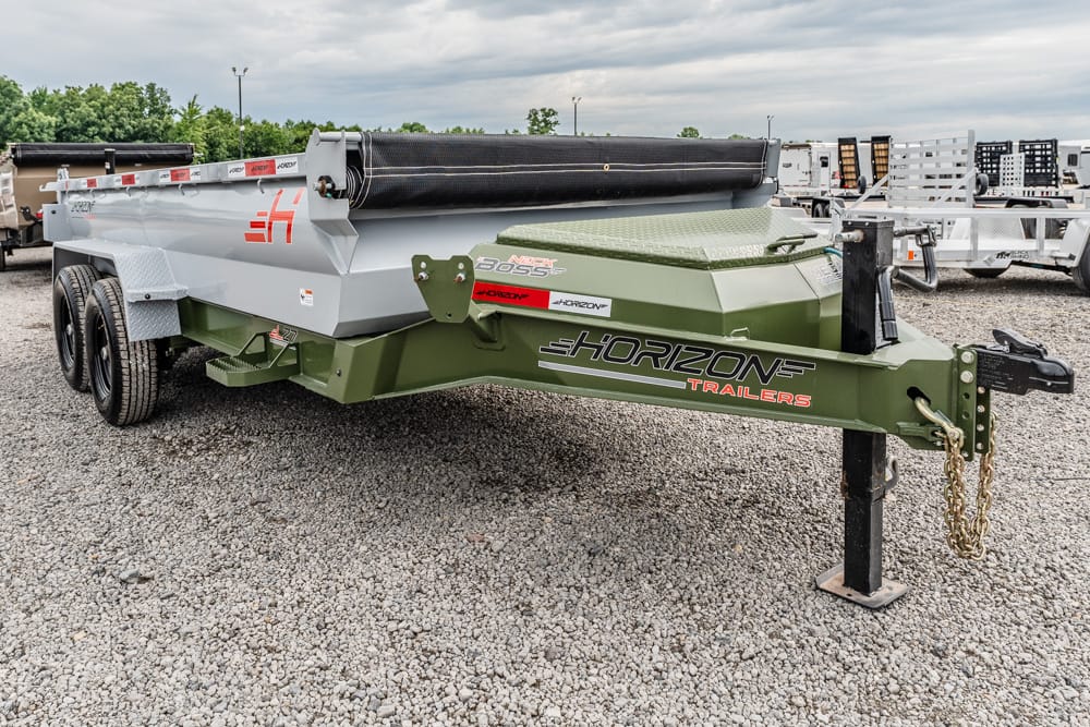 Green Horizon Trailers gooseneck trailer on a gravel lot, showing hitch, dual axles, and a roller tarp system with a gray bed rail nearby