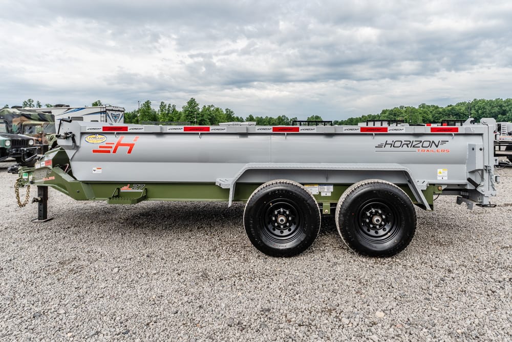 Horizon Trailers dump trailer with dual axles on a gravel lot, side view showcasing branding and safety decals.