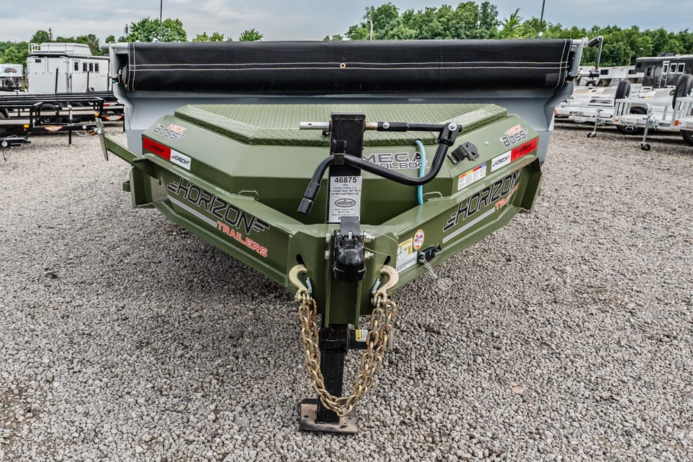 Front view of a green Horizon Trailers Mega Boss dump trailer on a gravel lot, with safety chains and hitch visible and other trailers in the background.