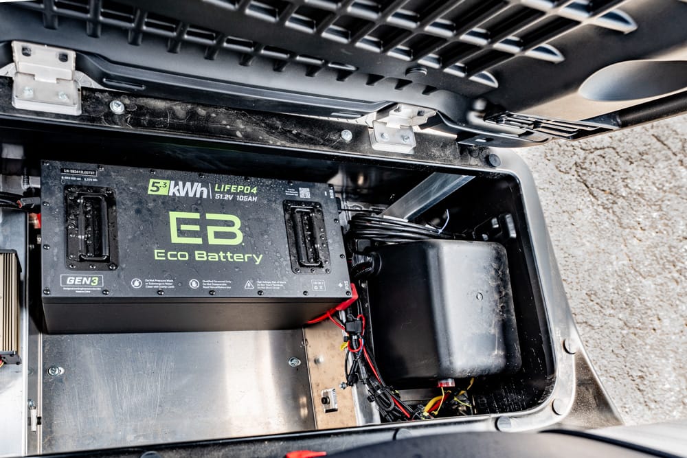 EB Eco Battery module labeled '5.3 kWh LIFE04' mounted inside a metal compartment with red and black wires nearby.