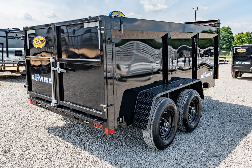 Black dual‑axle dump trailer with diamond-plate fenders on a gravel lot, Leonard logo visible on the side.