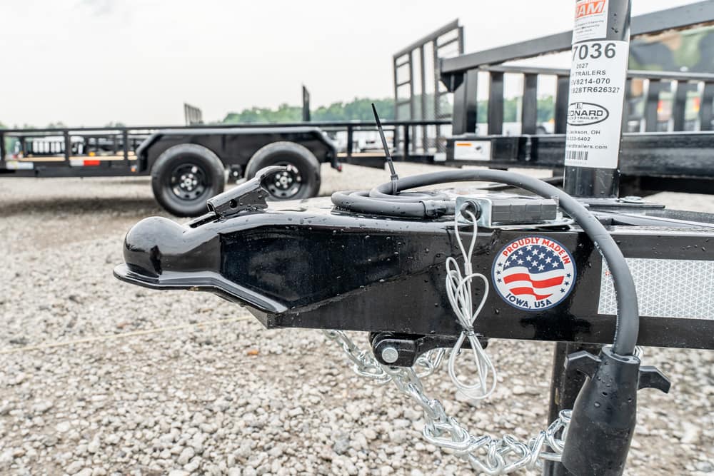 Close-up of a black trailer hitch with silver chains, wiring, and a 'Proudly Made in Iowa, USA' sticker on the frame.