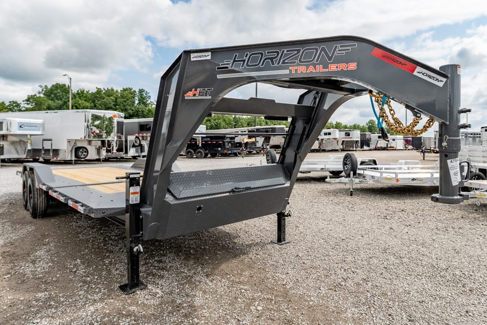 Gooseneck trailer with Horizon Trailers branding on a gravel lot, with other trailers in the background.