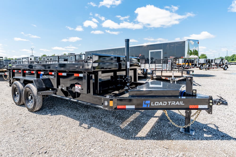 Black Load Trail dump trailer with dual axles on a gravel lot, front hitch and jack in foreground.