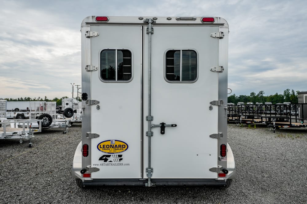 Back view of a white enclosed trailer with two small windows, rear doors secured by latches, and a Leonard Truck & Trailer logo on the lower left corner.