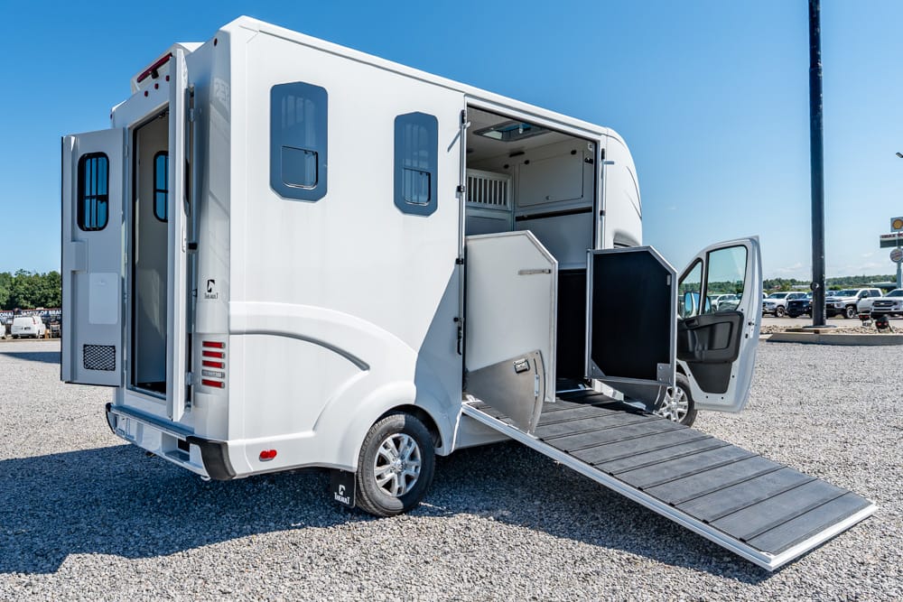 White wheelchair-accessible van with a fold-out ramp extended to the ground and multiple doors open showing interior access points.