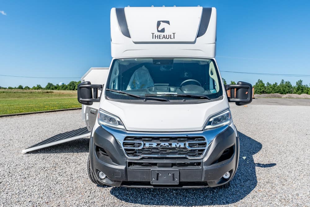 Front view of a white Theault mobility van with a deployed left-side ramp.