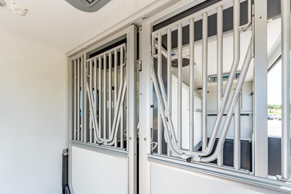 Interior of a horse trailer showing metal divider bars and stalls