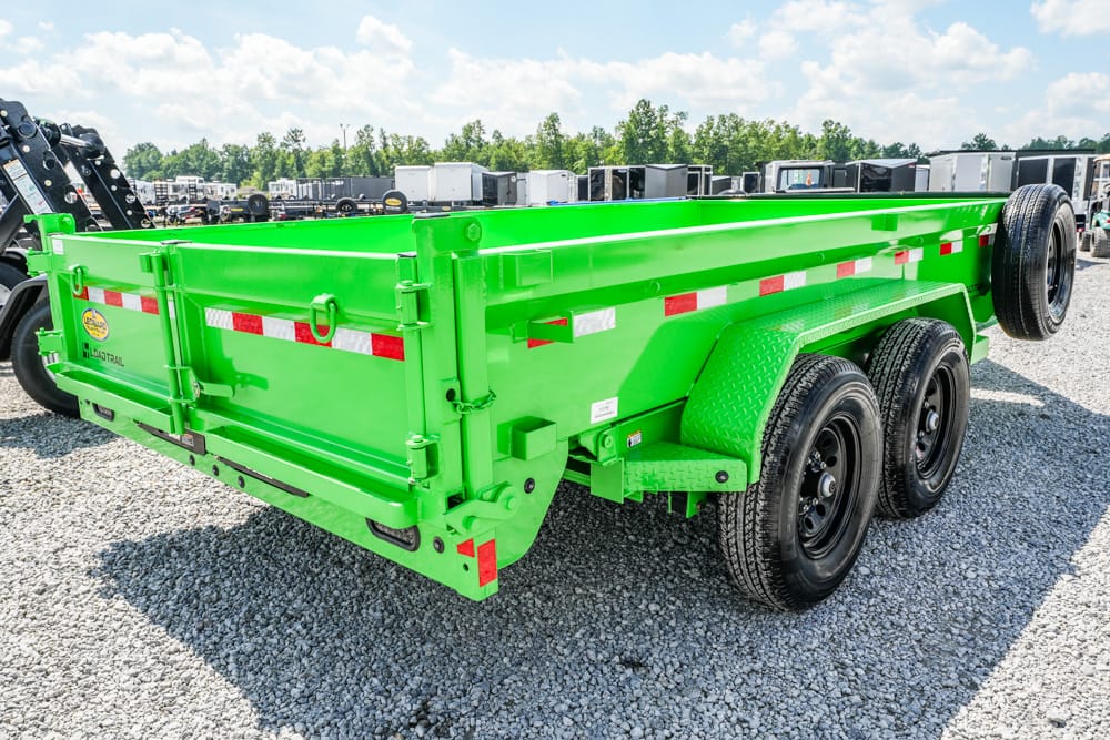 Bright green dual-axle dump trailer on a gravel lot with other trailers in the background.