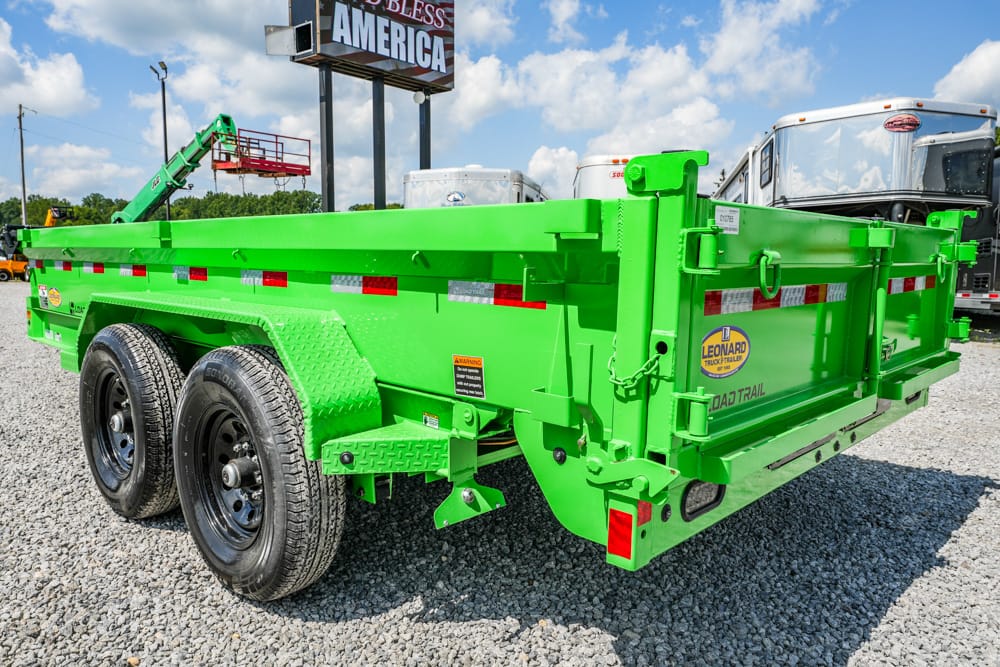 Bright green dump trailer with dual axles parked on gravel, rear gate closed. Innovations and safety reflectors visible on sides.