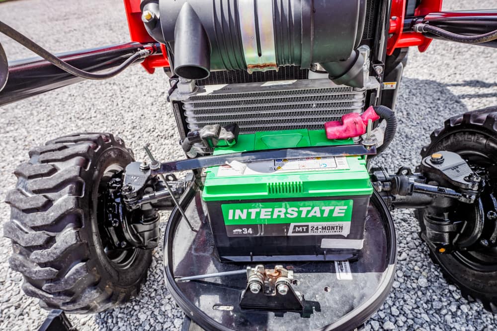 Green Interstate battery installed on a small off-road vehicle, with tires and engine components around it.