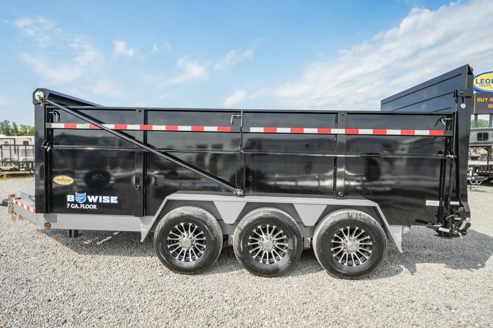 Black three-axle dump trailer on gravel, side view with red/white reflectors and branding, labeled BowWise 7 GA Floor.