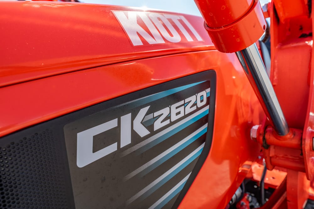 Close-up of an orange CK-2620 tractor panel with a Motul sticker and blue‑accent graphic lines on the side panel.