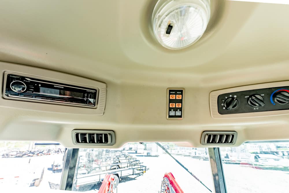 Cabin ceiling with a Kenwood stereo, climate dials, air vents, and a dome light.