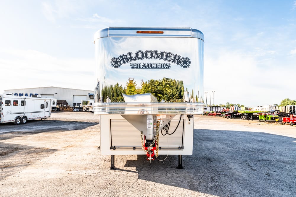 Shiny Bloomer Trailers truck trailer in a gravel lot with other trailers in the background and blue sky above