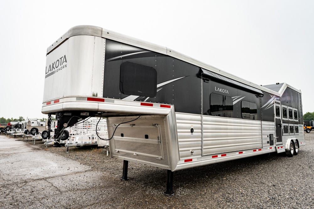 Lakota horse trailer with living quarters parked on a gravel lot.