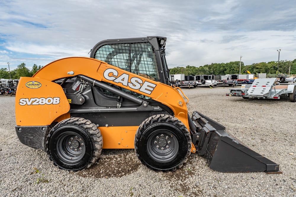 Orange CASE SV280B skid-steer loader with a front bucket on a gravel lot at an equipment yard