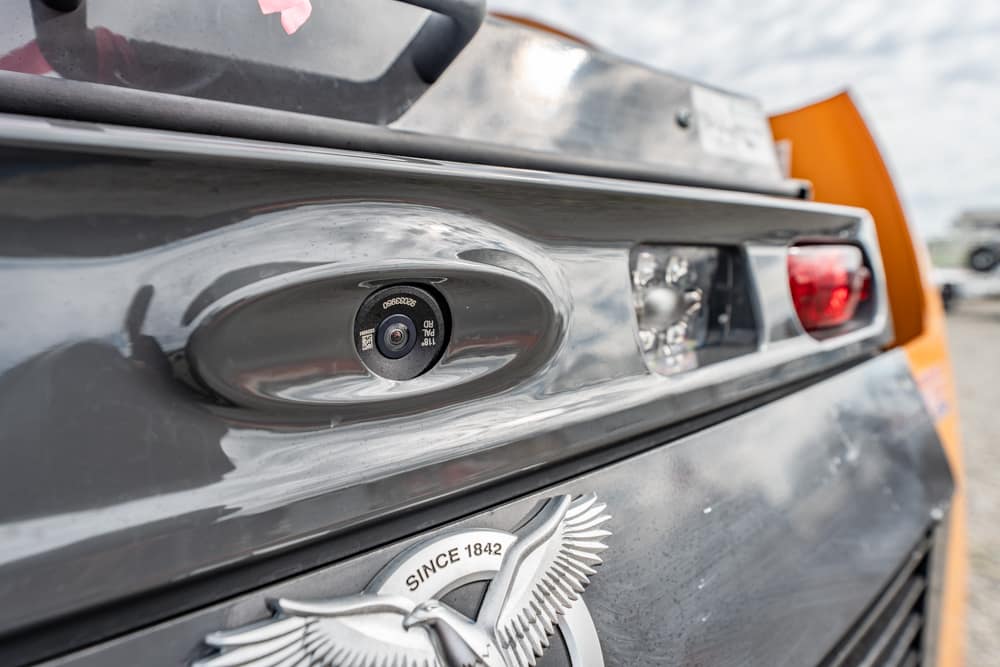 Close-up of a dark gray truck rear with a circular rear-view camera and a winged emblem reading SINCE 1842.