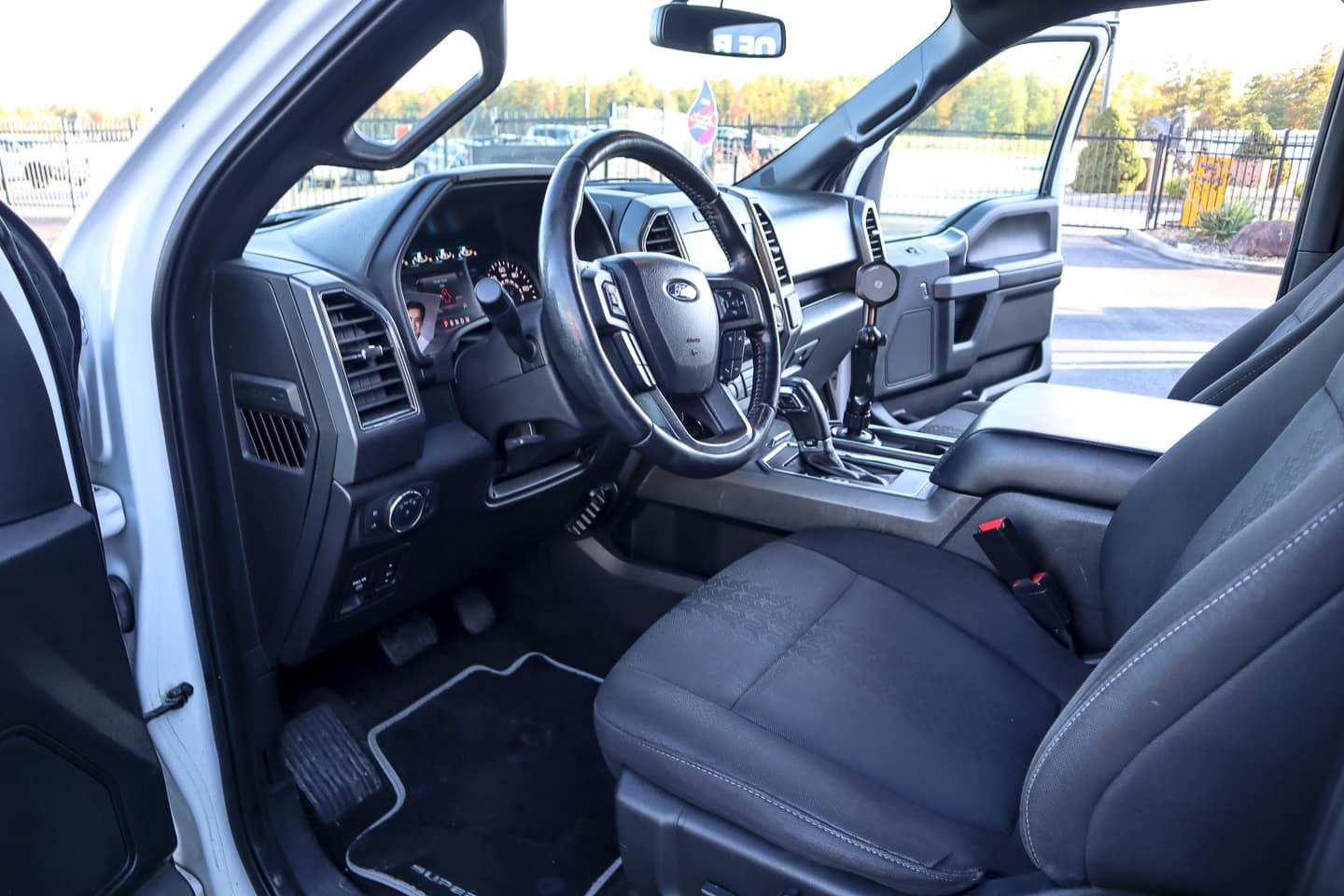 Interior of a pickup truck showing the driver’s seat, steering wheel, center console, and dashboard.