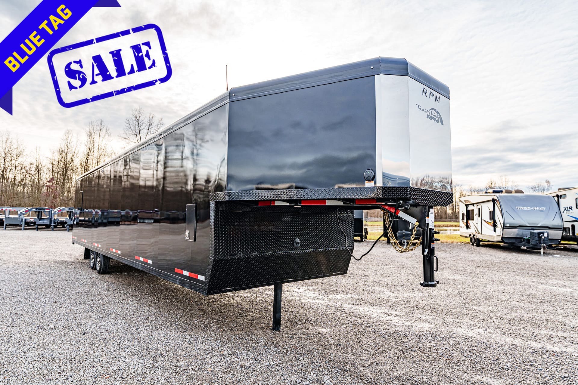 Enclosed black trailer for sale with a blue 'SALE' stamp and a blue diagonal 'BLUE TAG' banner in the corner.