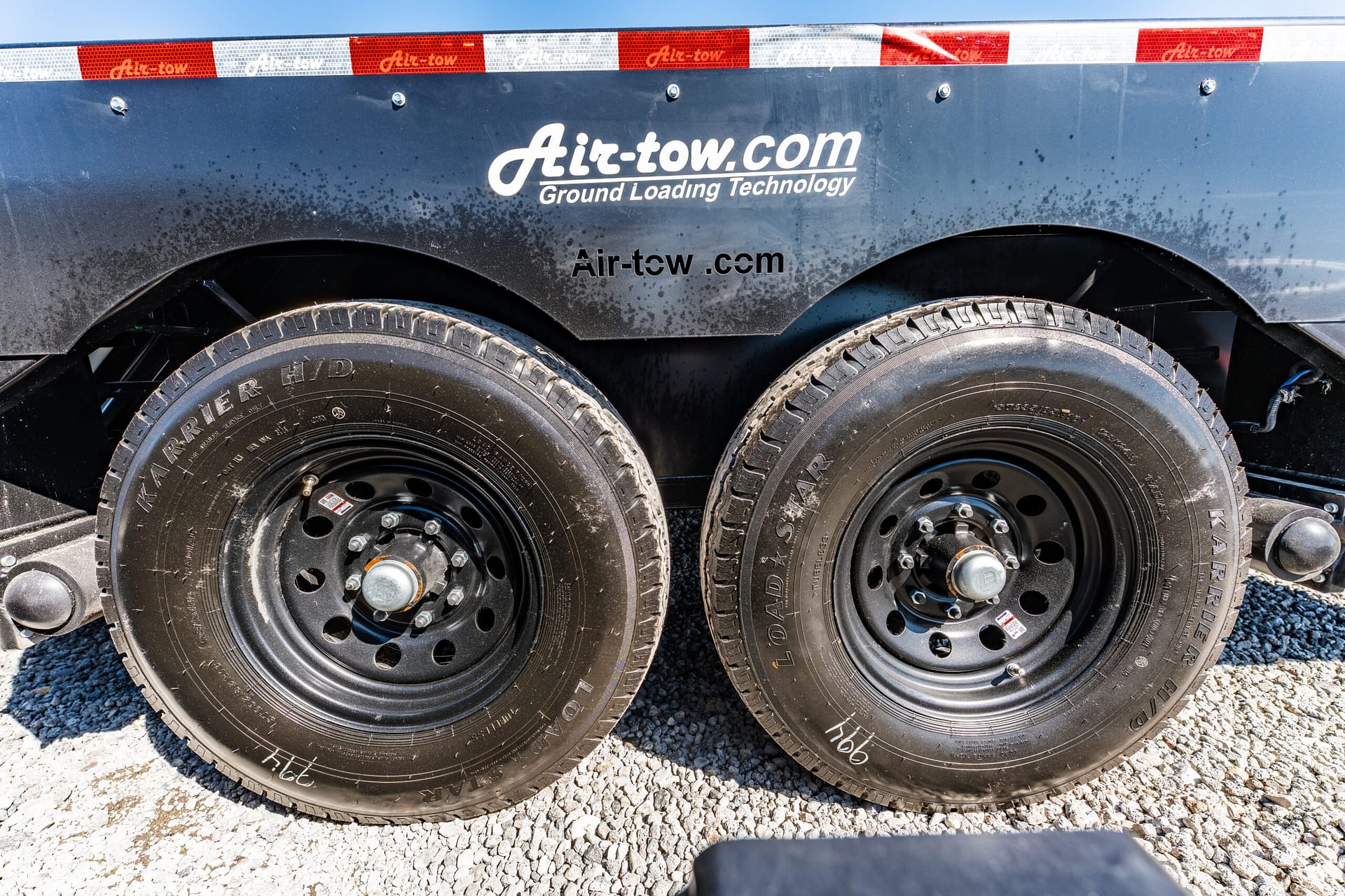 Close-up of two large truck wheels with a dark splashguard showing the Air-tow.com logo and 'Ground Loading Technology'.